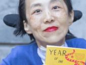 Alice Wong holds a copy of her memoir, Year of the Tiger: An Activist's Life.